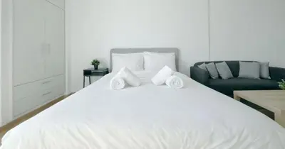 a white bed with two towels on top of it at Athens View Studio Near Lycabettus Hill by MPS in Athens
