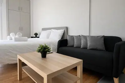 a bedroom with a bed and a couch and a coffee table at Athens View Studio Near Lycabettus Hill by MPS in Athens