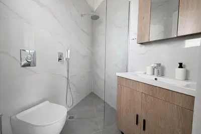 a white bathroom with a toilet and a sink at Athens View Studio Near Lycabettus Hill by MPS in Athens