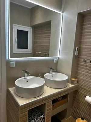 a bathroom with two sinks and a mirror at Hephaestus by Heloni Apartments in Athens