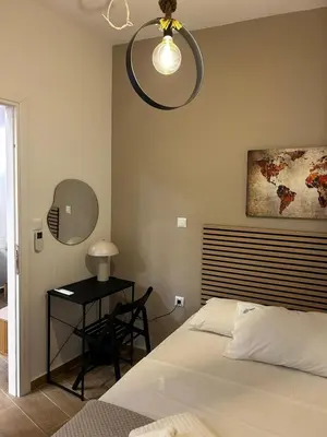 a bedroom with a bed and a table with a mirror at Hephaestus by Heloni Apartments in Athens