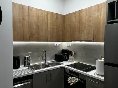 a kitchen with a sink and wooden cabinets at Hephaestus by Heloni Apartments in Athens