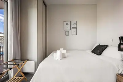 a bedroom with a white bed and a window at Ioli Seafront Hideaway by Porto Rafti Marina in Porto Rafti