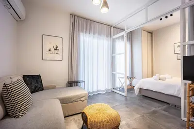 a living room with a couch and a bed at Ioli Seafront Hideaway by Porto Rafti Marina in Porto Rafti