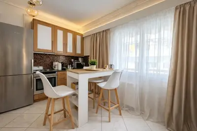 a kitchen with a counter with stools and a refrigerator at Like a Royal - Luxury Boho Apartment in Glyfada in Athens