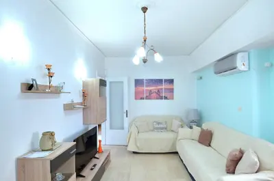a living room with a couch and a chair at A cute and comfortable two bedroom apartment in Piraeus