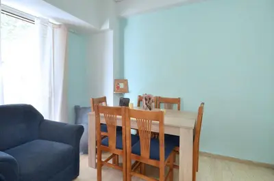 a dining room with a table and chairs and a couch at A cute and comfortable two bedroom apartment in Piraeus