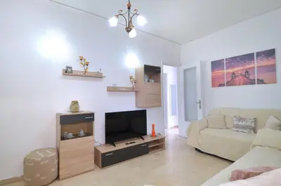 a living room with a couch and a flat screen tv at A cute and comfortable two bedroom apartment in Piraeus