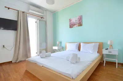 a bedroom with a large bed with a blue wall at A cute and comfortable two bedroom apartment in Piraeus