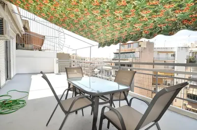a table and chairs on a balcony with a view at A cute and comfortable two bedroom apartment in Piraeus