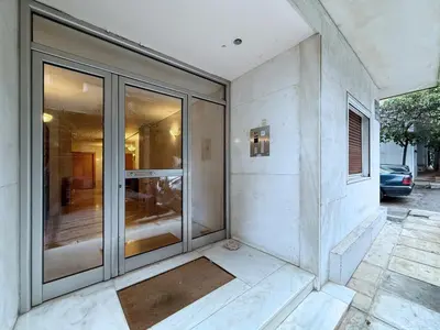 a building with glass doors on the side of it at Charming and cozy studio apartment in Athens
