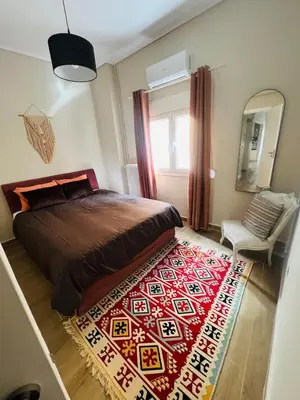 a bedroom with a bed and a red rug at BoraBora Flat in Piraeus