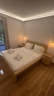a bedroom with a large bed with two towels on it at Beige House in Saronida
