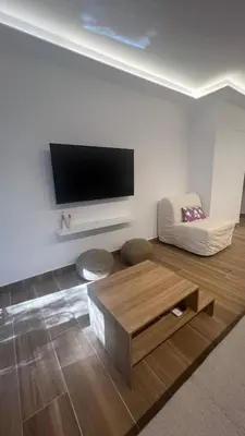 a living room with a flat screen tv on a wall at Beige House in Saronida