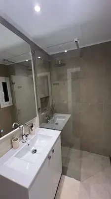 a bathroom with a white sink and a shower at Beige House in Saronida