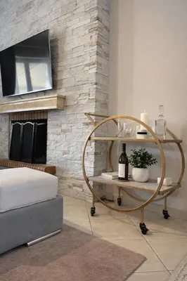a room with a round table with a tv on a brick wall at Bright & Spacious 80sqm Apartment Glyfada,Balcony in Athens