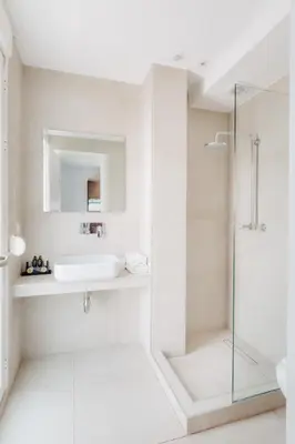 a white bathroom with a sink and a shower at Athens Backpackers in Athens