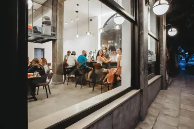 a group of people sitting at tables in a restaurant at Athens Backpackers in Athens