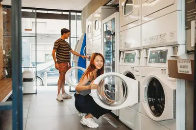 a woman holding two washing machines in a store at Athens Backpackers in Athens