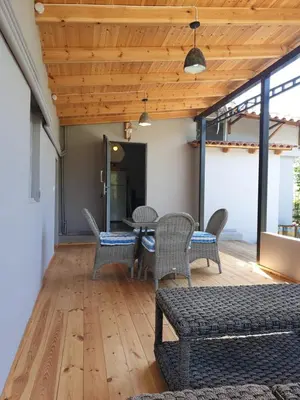 a living room with chairs and a table at Varkiza's Cottages in Varkiza