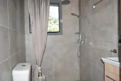 a bathroom with a shower and a toilet at Varkiza's Cottages in Varkiza