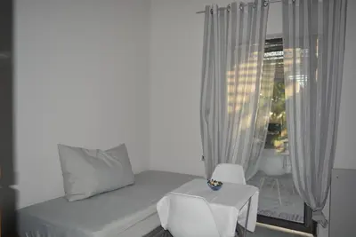 a bedroom with a bed and a table and a window at Varkiza's Cottages in Varkiza