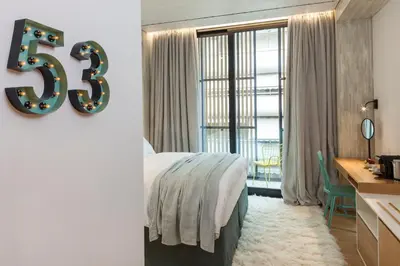 a bedroom with a large bed and a large window at Coco-Mat Hotel Athens in Athens