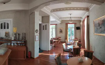 a living room with tables and chairs and a dining room at Cecil Hotel in Athens