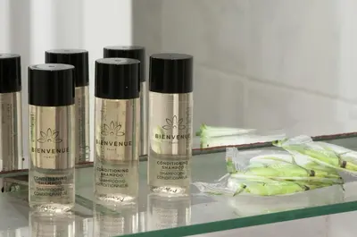 a group of three bottles of makeup on a glass table at Cecil Hotel in Athens