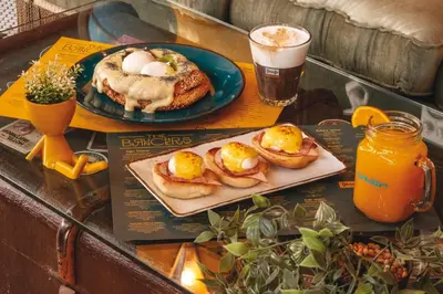 a table with a plate of eggs and pancakes and a drink at Concierge Monastiraki in Athens
