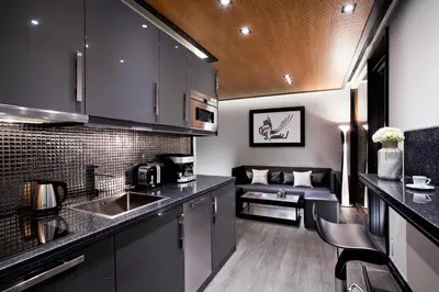 a kitchen with black cabinets and a couch at MET34 Athens in Athens