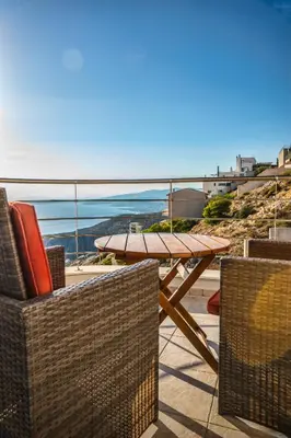 a table and chairs on a patio with a view of the ocean at Viva B&B in Anavissos