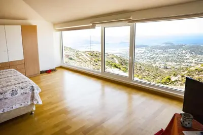 a bedroom with a bed and large windows at Viva B&B in Anavissos