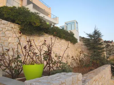 a stone wall with a green pot in front of a building at Viva B&B in Anavissos