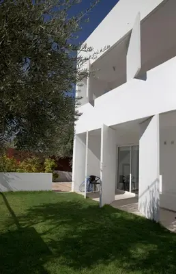 a white house with a lawn in front of it at Infinity White Complex by GK Properties in Porto Rafti