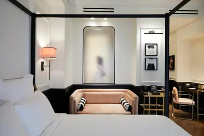 a bedroom with a bed and a chair and a mirror at Villa Brown Ermou, a member of Brown Hotels in Athens