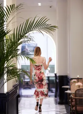 a woman walking down a hallway with a plant at Villa Brown Ermou, a member of Brown Hotels in Athens