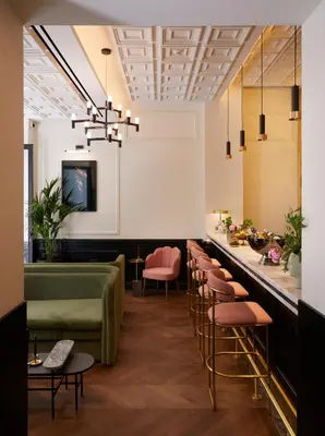 a bar with pink chairs and a green couch at Villa Brown Ermou, a member of Brown Hotels in Athens