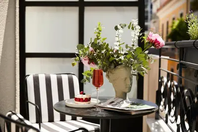a table with a vase with a cake on a balcony at Villa Brown Ermou, a member of Brown Hotels in Athens