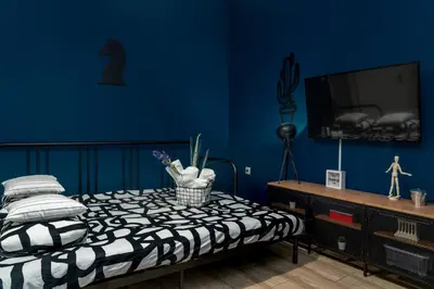a bedroom with a bed and a blue wall at Apartment at the foothills of Acropolis in Athens