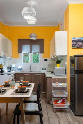 a kitchen with a table and a yellow wall at Apartment at the foothills of Acropolis in Athens