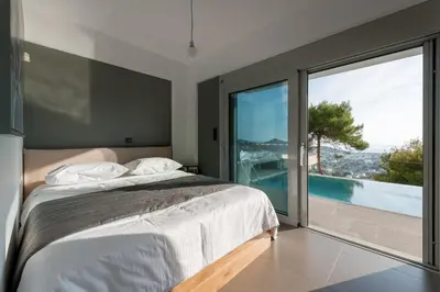 a bedroom with a bed and a large window at Joy Villa Agia Marina in Aghia Marina