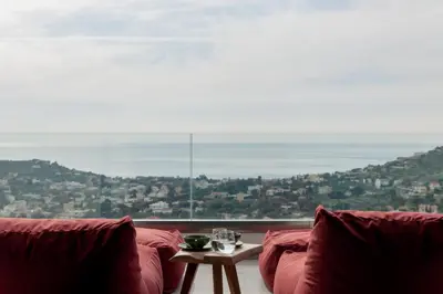 a living room with a couch and a large window at Joy Villa Agia Marina in Aghia Marina