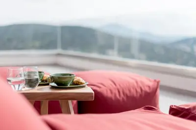 a table with a plate of food and glasses of water at Joy Villa Agia Marina in Aghia Marina