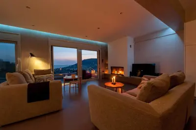 a living room with two couches and a fireplace at Joy Villa Agia Marina in Aghia Marina