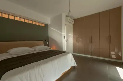 a bedroom with a large bed and a large cabinet at Joy Villa Agia Marina in Aghia Marina