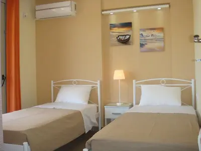 a bedroom with two beds and a lamp at Sandra's Sea View at Sounio in Sounio