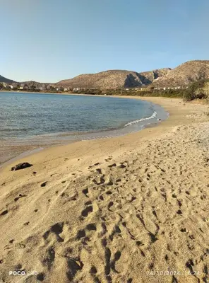 a beach with footprints in the sand next to the water at Sandra's Sea View at Sounio in Sounio