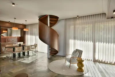 a living room with a staircase and a table and chairs at KARYATIS LUXURY MAISONETTE by K&K in Athens