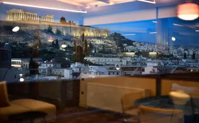 a view of a city from a window in a restaurant at KARYATIS LUXURY MAISONETTE by K&K in Athens